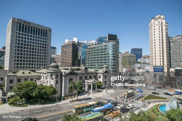 Pedestrians cross a road outside the entrance to the Bank of Korea museum at the central bank's headquarters in Seoul, South Korea, on Thursday, Aug....