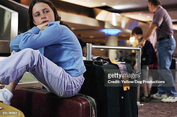 bored girl and family in airport - luggage trolley stockfoto's en -beelden