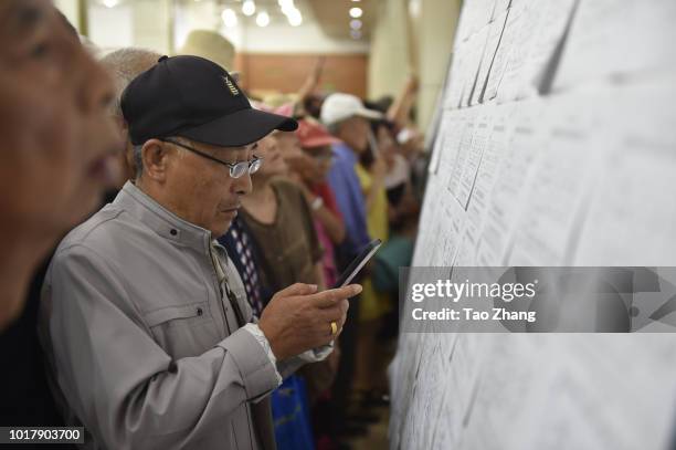 Elderly people view marriage-seeking leaflets during a blind date event for Chinese valentine's day on August 17, 2018 in Harbin, China.More and more...