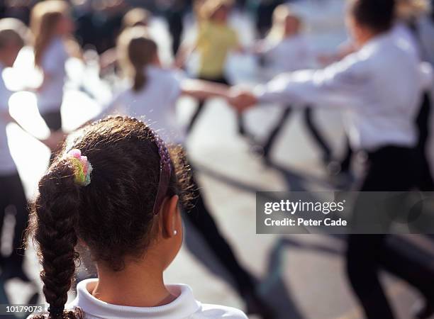 girl watching other children playing - exclusión fotografías e imágenes de stock