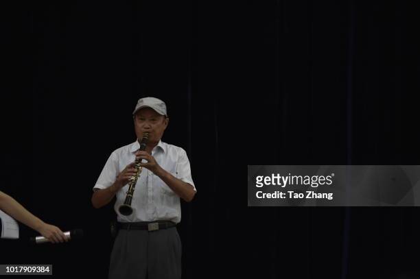 Elderly man performs during a blind date event for chinese valentine's day on August 17, 2018 in Harbin, China.More and more single elderly people...