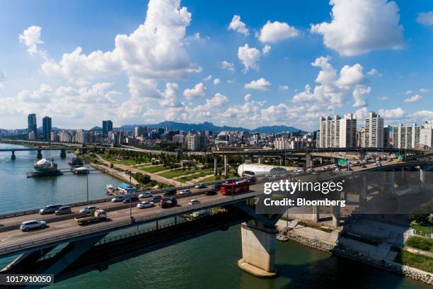 Vehicles cross a bridge as buildings stand in the background in this aerial photograph taken in Seoul, South Korea, on Saturday, Aug. 11, 2018. South...