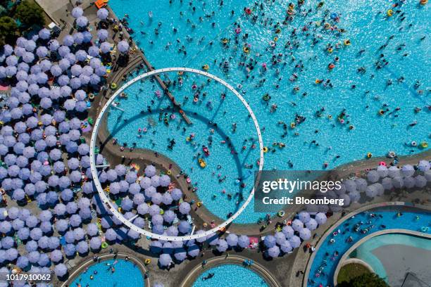 Parasols stand as people bathe in swimming pools at Ttukseom Hangang Park in this aerial photograph taken in Seoul, South Korea, on Saturday, Aug....
