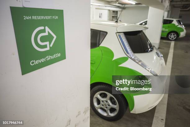 Pair of Nissan Motor Co. Leaf electric automobiles, operated by ride-sharing startup CleverShuttle, charge their batteries in parking bays in Berlin,...