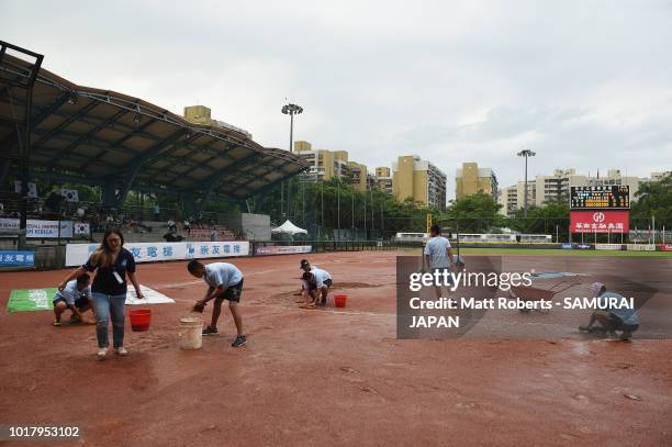 Ground staff sponge the excess water as the start of play is delayed due to heavy rain in the BFA U-12 Asian Championship Super Round match between...
