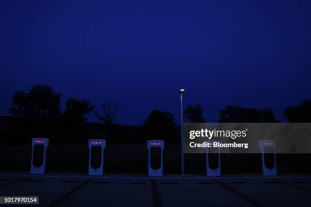 Tesla Inc. Supercharger stations stand illuminated at night in Rubigen, Switzerland, on Thursday, Aug. 16, 2018. Tesla chief executive officer Elon...