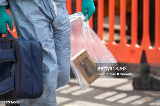 Forensic officer carries a knife from the scene this morning after an incident in which four boys were stabbed on August 17, 2018 in London, England....