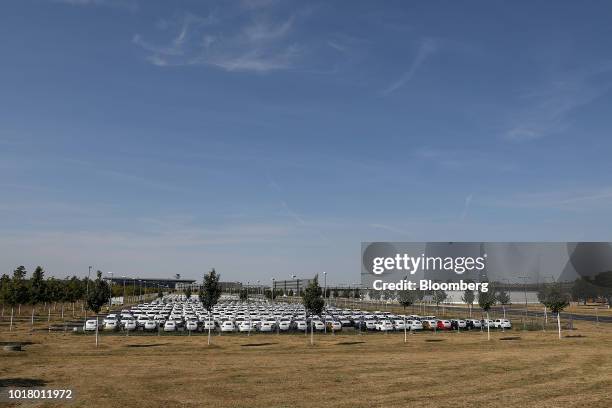 Protective covers rest on new Volkswagen AG automobiles as they sit stockpiled in a parking lot at Willy Brandt Berlin Brandenburg International...