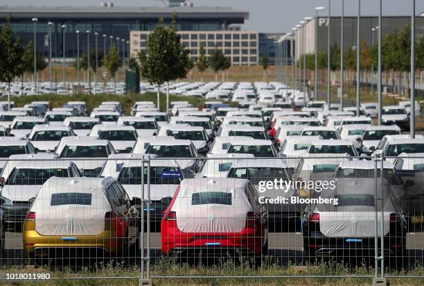 Protective covers rest on new Volkswagen AG automobiles as they sit stockpiled in a parking lot at Willy Brandt Berlin Brandenburg International...