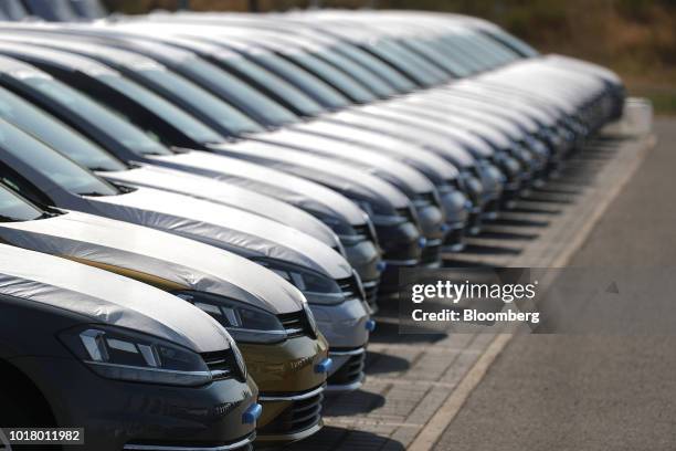 Protective covers rest on new Volkswagen AG automobiles as they sit stockpiled in a parking lot at Willy Brandt Berlin Brandenburg International...