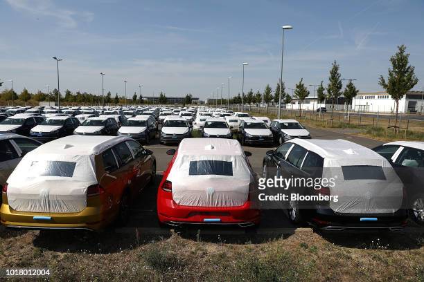 Protective covers rest on new Volkswagen AG automobiles as they sit stockpiled in a parking lot at Willy Brandt Berlin Brandenburg International...