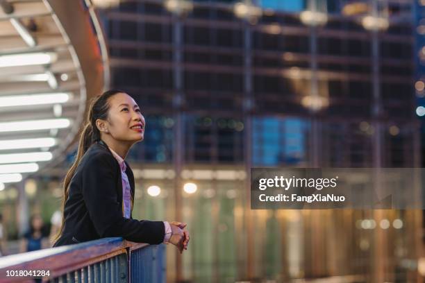 business woman standing on pedestrian bridge at night - pedestrian overpass stock pictures, royalty-free photos & images