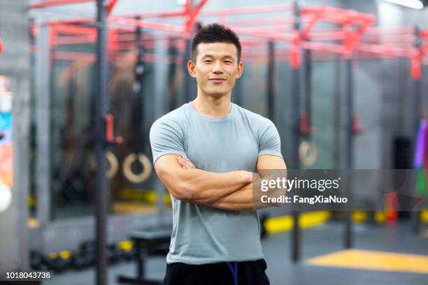 retrato de chino entrenador personal en gimnasio - sport coach fotografías e imágenes de stock