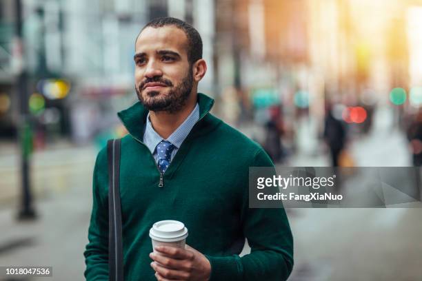 straat portret van een jonge zakenman die houden van een kopje koffie - first time stockfoto's en -beelden