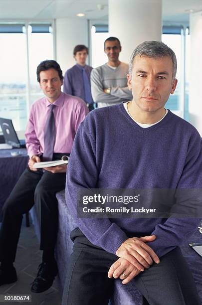 portrait of businessmen sitting and standing - grupo pequeno de pessoas imagens e fotografias de stock