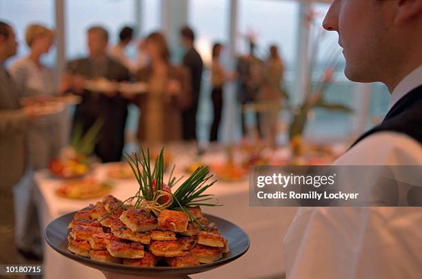 people gathering, waiter with food platter - indústria de comida e bebida - fotografias e filmes do acervo