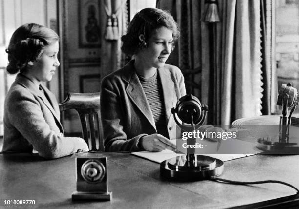 Picture taken October 1940 in Windsor shows the Britain's Princess Elizabeth and her sister Princess Margaret sending a message during the BBC's...