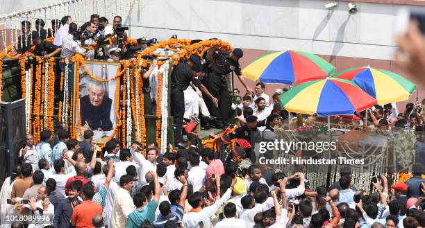 Followers of Atal Bihari Vajpayee take part in the funeral procession from BJP headquarters, after BJP workers and leaders paid their last respects...