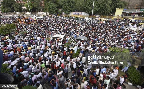 Followers of former Prime Minister Atal Bihari Vajpayee take part in the last rites as his funeral procession passes by ITO crossing on August 17,...