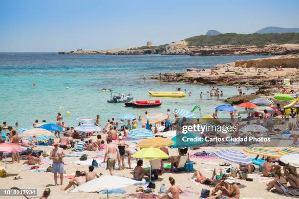 crowded beach during summer in ibiza, spain - spain tourism stock pictures, royalty-free photos & images