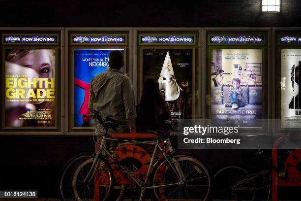 Pedestrians view movie posters displayed outside of the Landmark Century Centre Cinema in Chicago, Illinois, U.S., on Thursday, Aug. 16, 2018....