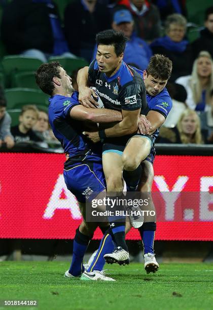 Akihito Yamada of Japan's Wild Knights is tackled by Ian Prior and Brad Lacey from Western Force during their World Series rugby match in Perth on...