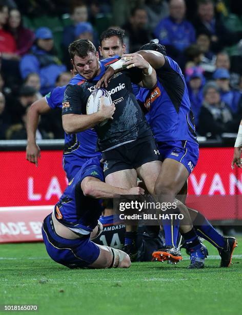 Tom Moloney of Japan's Wild Knights attempts to break through a tackle from Harrison Orr and Feleti Kaiutu by from Western Force during their World...