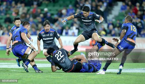 Rikiya Matsuda leaps over Takuya Yamasawa of Japan's Wild Knights as he is tackled by Henry Taefu from Western Force during their World Series rugby...