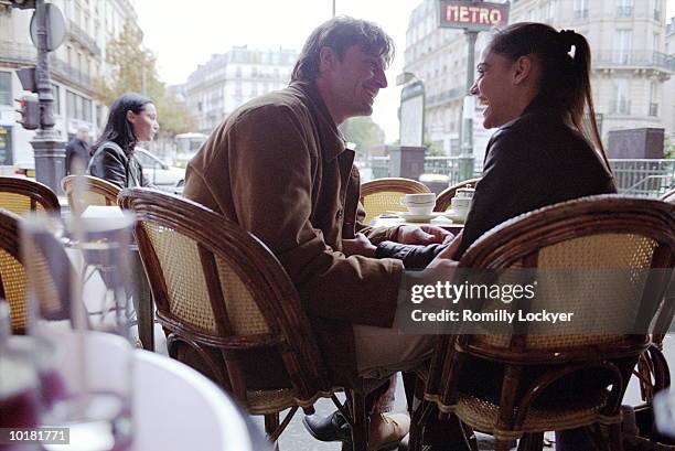 young man touching womans arm in cafe - couple paris stockfoto's en -beelden