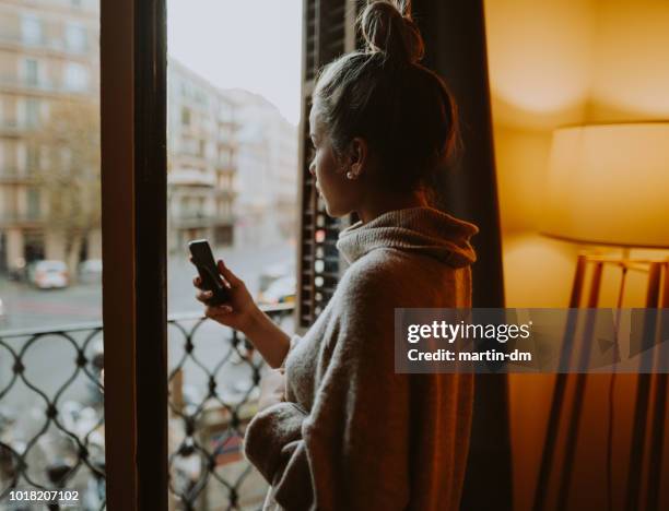 woman at home looking through the window - staring stock pictures, royalty-free photos & images