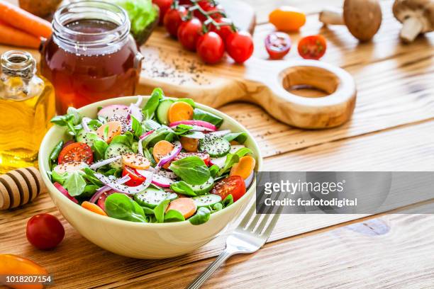 salad mix bowl shot on wooden picnic table - salad bowl stock pictures, royalty-free photos & images
