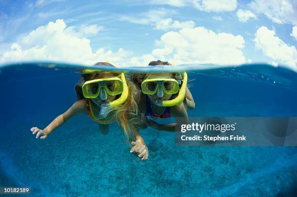 two young girls snorkeling (cayman) - family vacation stock pictures, royalty-free photos & images