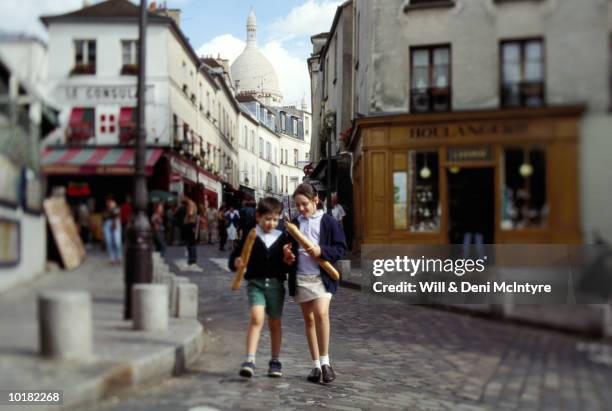 children with bread, montmartre, paris - french baguette stock-fotos und bilder