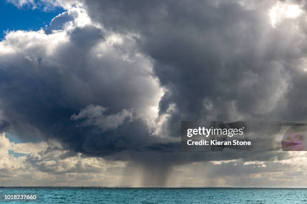 rain over ocean - overcast beach stock pictures, royalty-free photos & images