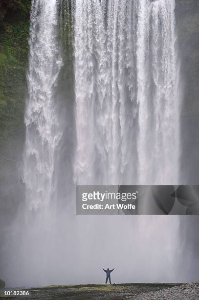 person in front of skogafoss falls - skogafoss waterfall stock pictures, royalty-free photos & images