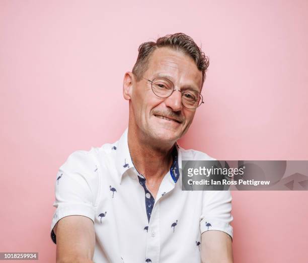 middle-aged man with glasses on pink background - pink collared shirt stock pictures, royalty-free photos & images