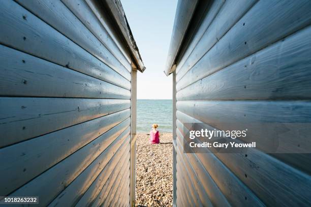 view between two beach huts to the beach - beach hut fotografías e imágenes de stock