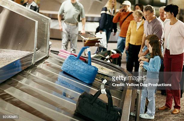 family waiting at baggage claim - baggage claim stock pictures, royalty-free photos & images