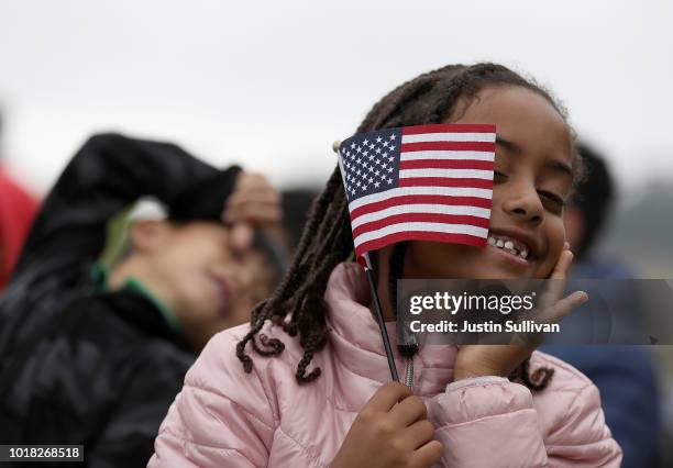 Sophia Biniam holds an American flag during a naturalization ceremony for kids between the ages of 6-12 at Crissy Field near the Golden Gate Bridge...