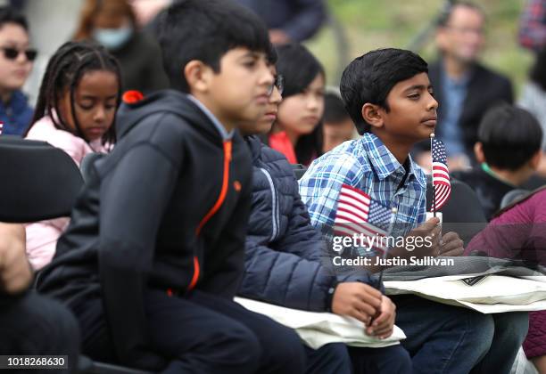 Children look on during a naturalization ceremony for kids between the ages of 6-12 at Crissy Field near the Golden Gate Bridge on August 17, 2018 in...