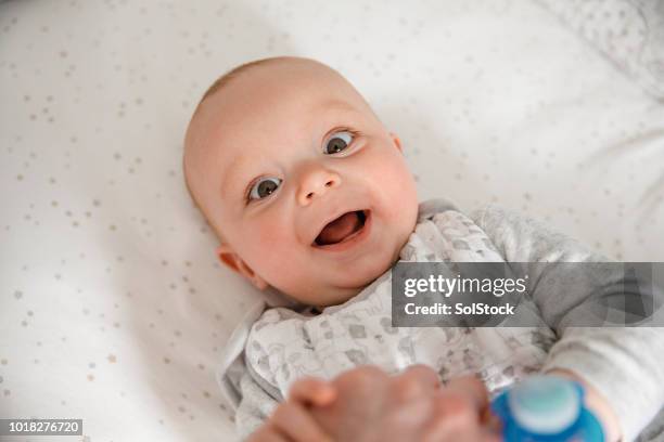 baby boy smiling at camera - baby crib stock pictures, royalty-free photos & images