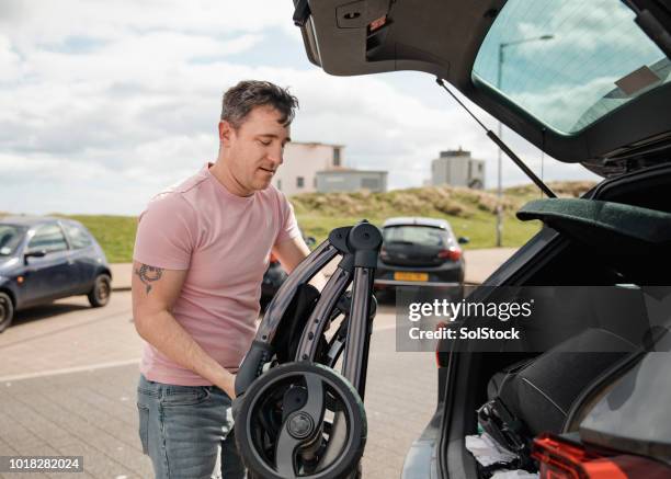 man unloading his car - stroller stock pictures, royalty-free photos & images