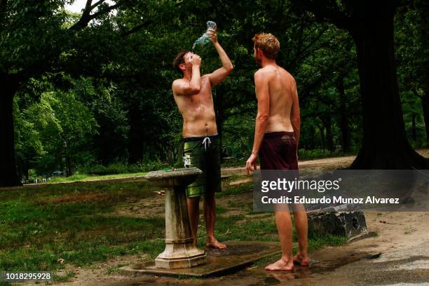 People cool theyself after playing beach volleyball at Central Park on August 17, 2018 in New York City. Severe thunderstorms and even an isolated...