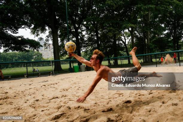 Man dives for the ball playing beach volleyball during a warm day at Central Park on August 17, 2018 in New York City. Severe thunderstorms and even...