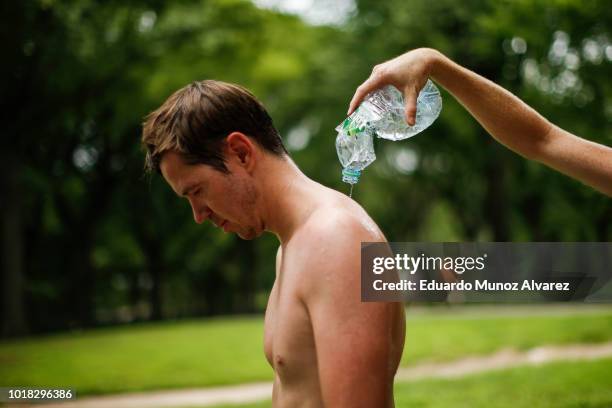 People cool themselves during a warm day at Central Park on August 17, 2018 in New York City. Severe thunderstorms and even an isolated tornado could...