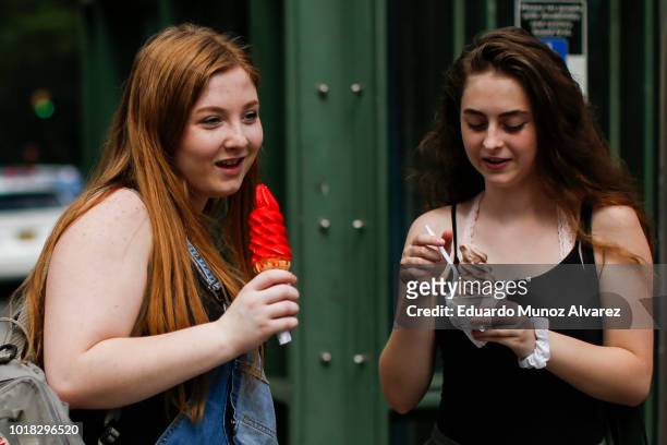 Women eat ice cream during a warm day at Central Park on August 17, 2018 in New York City. Severe thunderstorms and even an isolated tornado could...