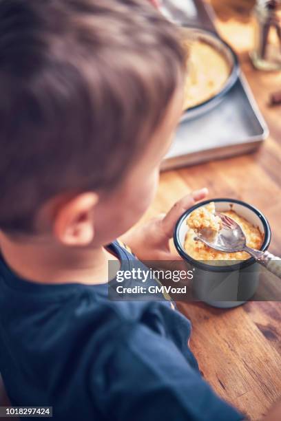 niedlichen kinder essen milch reis-pudding mit vanille und zimt - reispudding stock-fotos und bilder