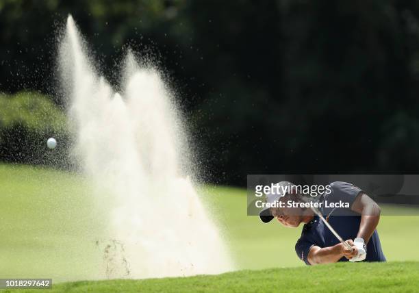 Si Woo Kim of South Korea plays a shot from a bunker on the tenth hole during the second round of the Wyndham Championship at Sedgefield Country Club...