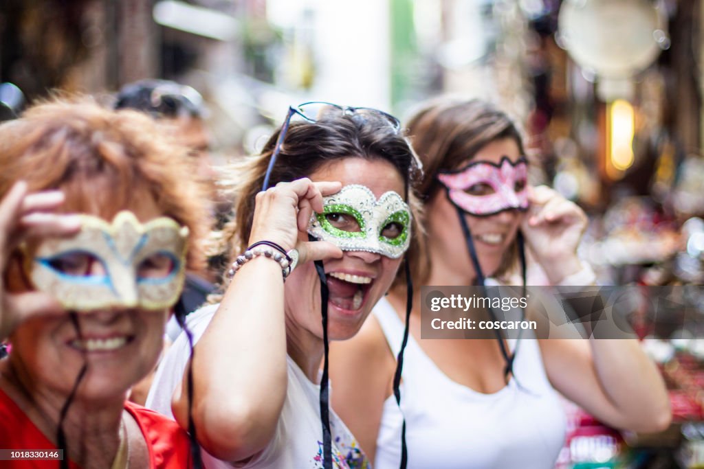 Three women with three masks on the streets of Naples, Italy