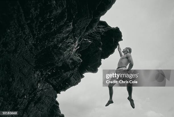 rock climber hanging from rock (toned black & white) - escalada livre imagens e fotografias de stock